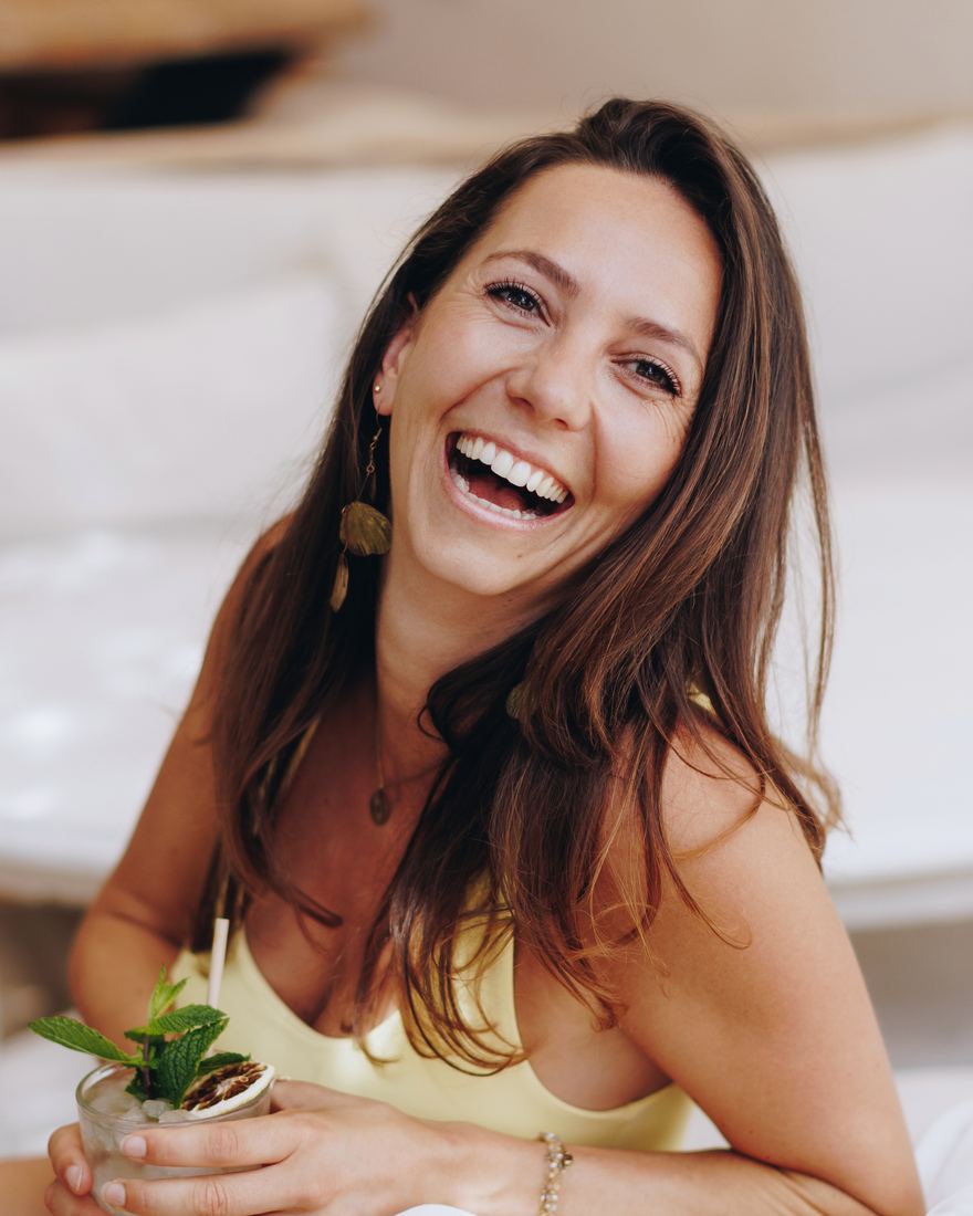 Ans, lachend met een glas in haar hand op een terras op Ibiza