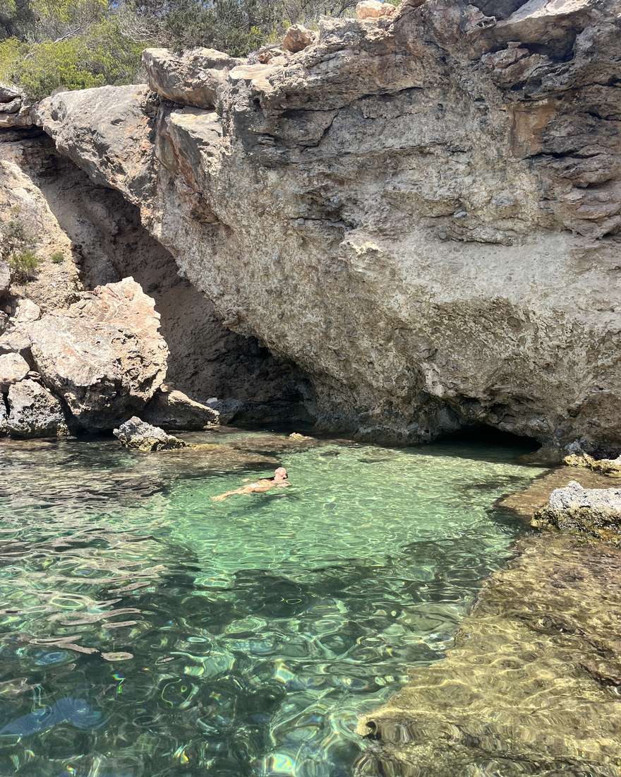 Zwemmen in helder turquoise water in een beschutte baai tussen de rotsen op Ibiza